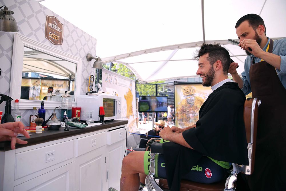 Nathan Haas gets his haircut in the mobile barbershop before the start of stage 14.