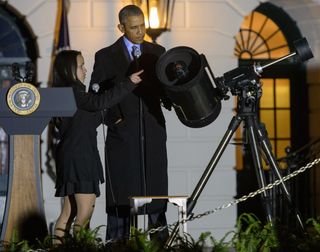 Agatha Sofia Alvarez-Bareiro, a 12th-grader from New York, showed President Barack Obama the different parts of a telescope before inviting him to use it to examine the moon, at the second White House Astronomy Night on Oct. 19.