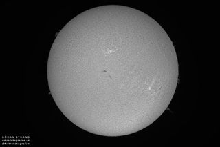 The original, black and white view of the sun and prominence (in the lower-right).