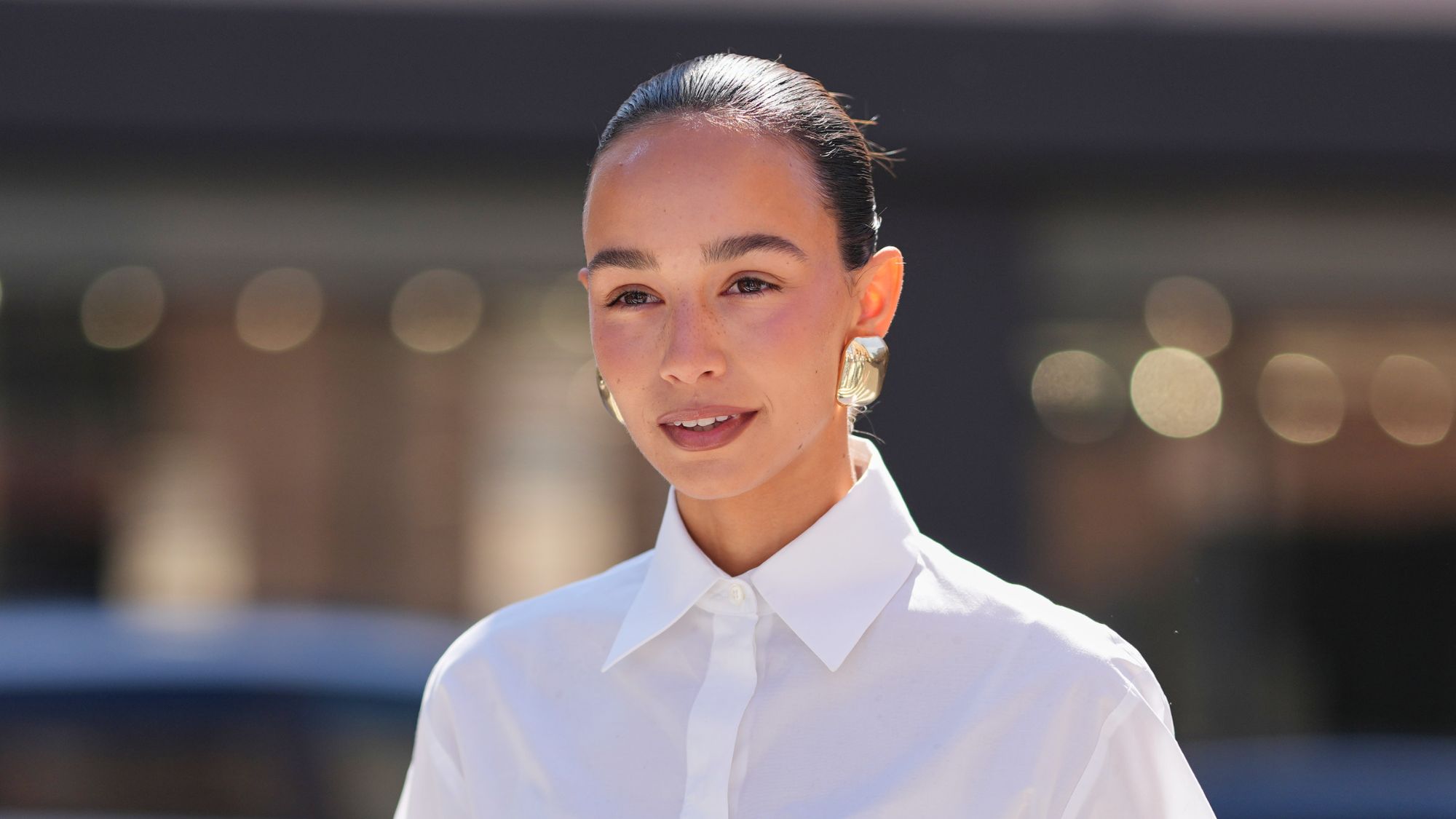 woman with slicked back hair and glowy skin