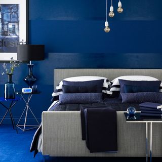 bedroom with blue wall and table lamp