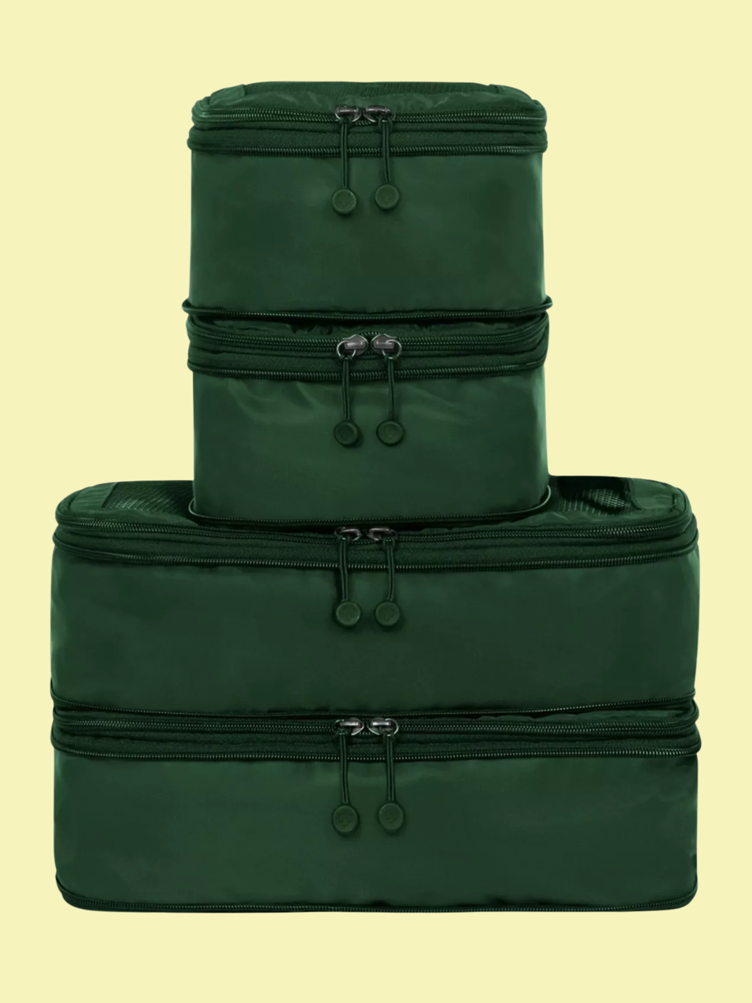 A set of four forest green packing cubes from Antler