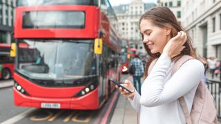 london bus with woman on phone in foreground