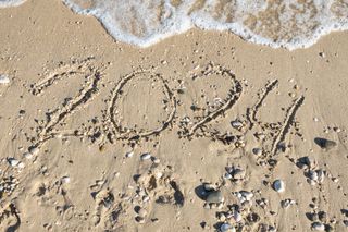 2024 written on the sandy seashore washed away by the wave