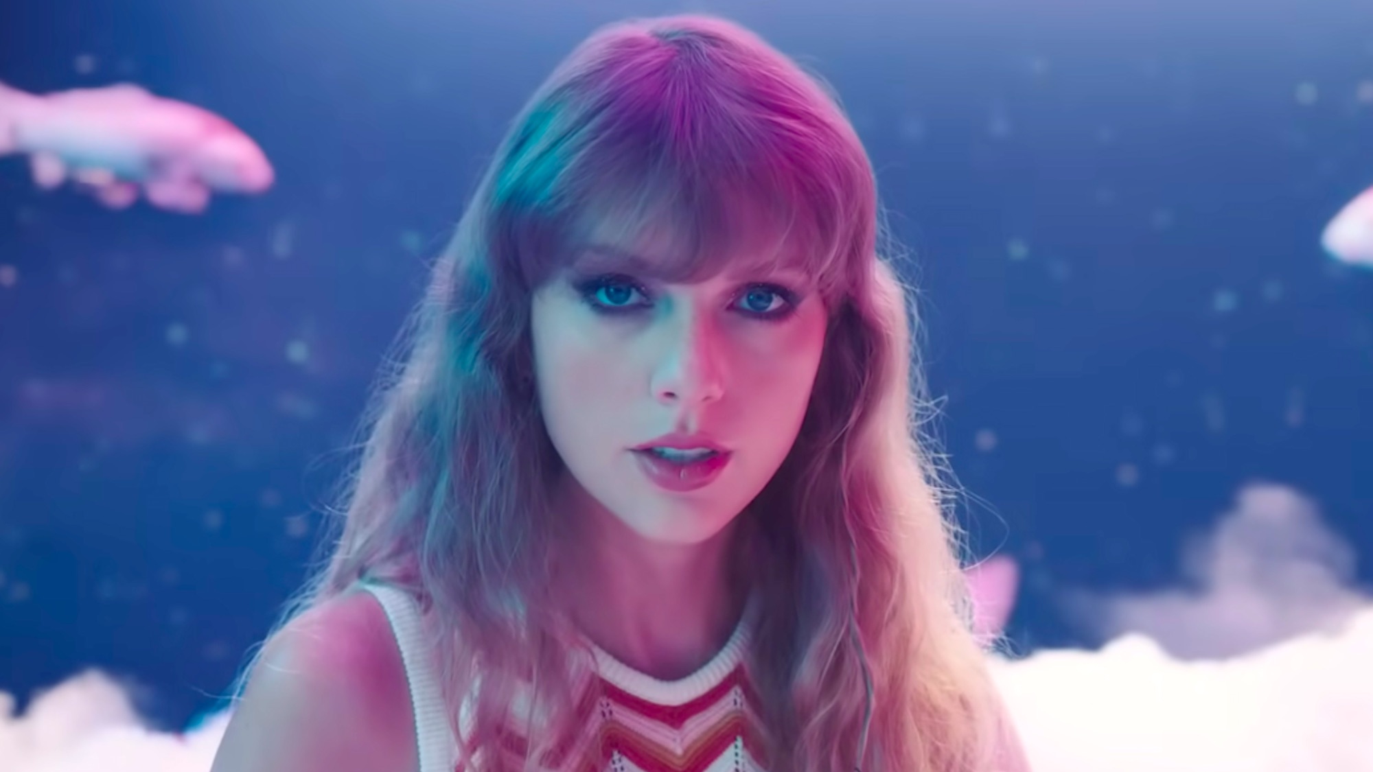 Taylor Swift wearing moody makeup with koi fish behind her in Lavender Haze music video.