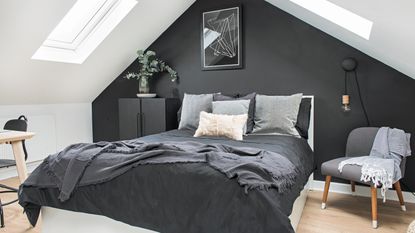 Black painted brick wall in the dining area of a kitchen extension, with white dining table and chairs