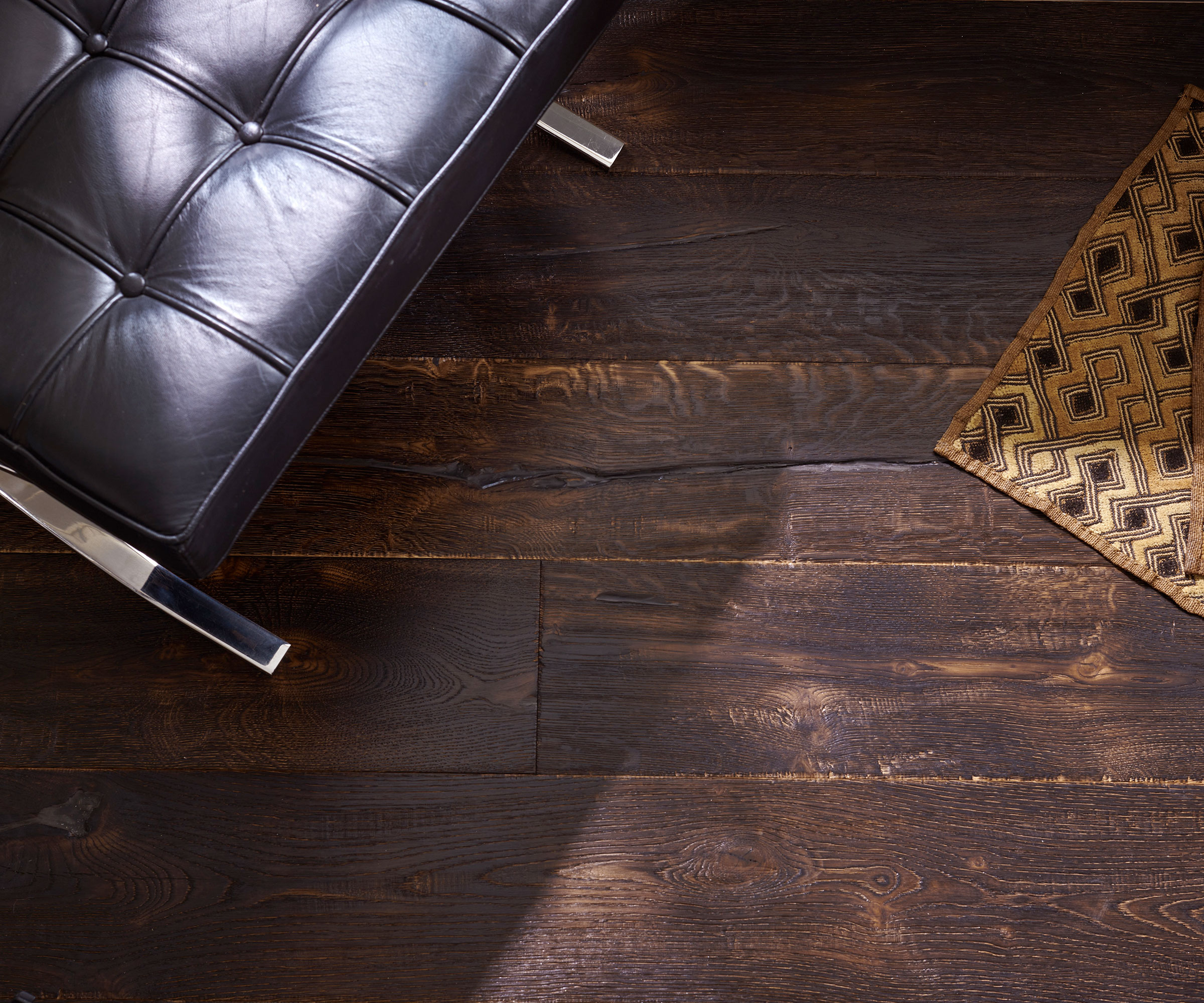 dark stained oak flooring with leather armchair