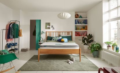 The Silentnight Studio Eco mattress pictured on a wooden bed frame in a modern white bedroom