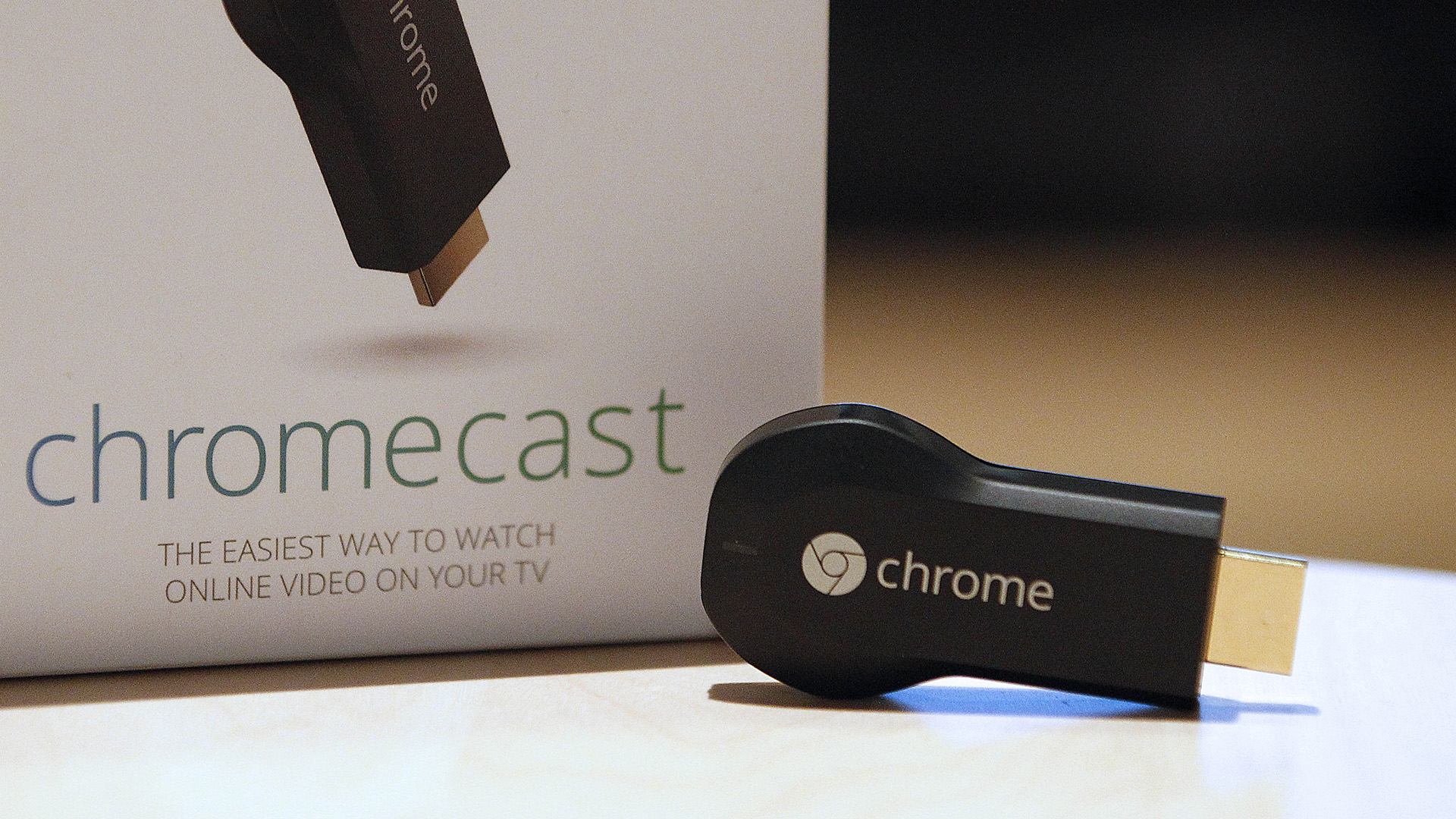 Google Chromecast first-gen on a table with its box