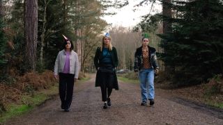 Bibi Garvey, Eva Garvey, and Becka Garvey wear party hats as they walk down a country road in Bad Sisters