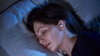 Woman sleeping wearing Bose Sleepbuds II earbuds.