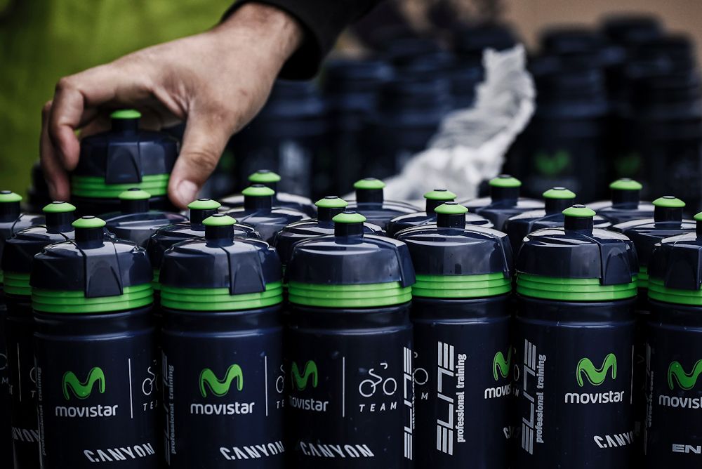 A person prepares water bottles in front of the hotel of Spain's Movistar cycling team in Coutances a day before the start of the 2016 Tour de France