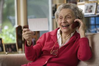 A happy senior woman talks on the phone.