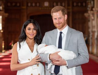 Prince Harry, Duke of Sussex and Meghan, Duchess of Sussex, pose with their newborn son Archie Harrison Mountbatten-Windsor during a photocall in St George's Hall at Windsor Castle on May 8, 2019
