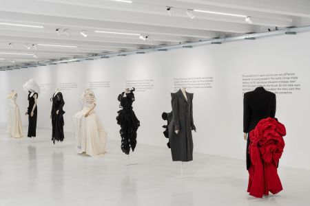 Installation image of Yohji Yamamoto exhibition at 10 Corso Como featuring sculptural black, white and red dresses