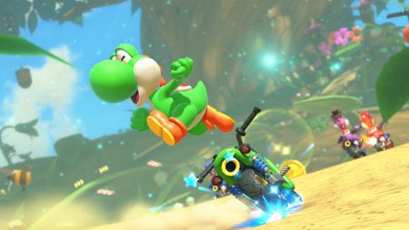 Mario Kart World screenshot showing Yoshi leaping off of his bike in celebration