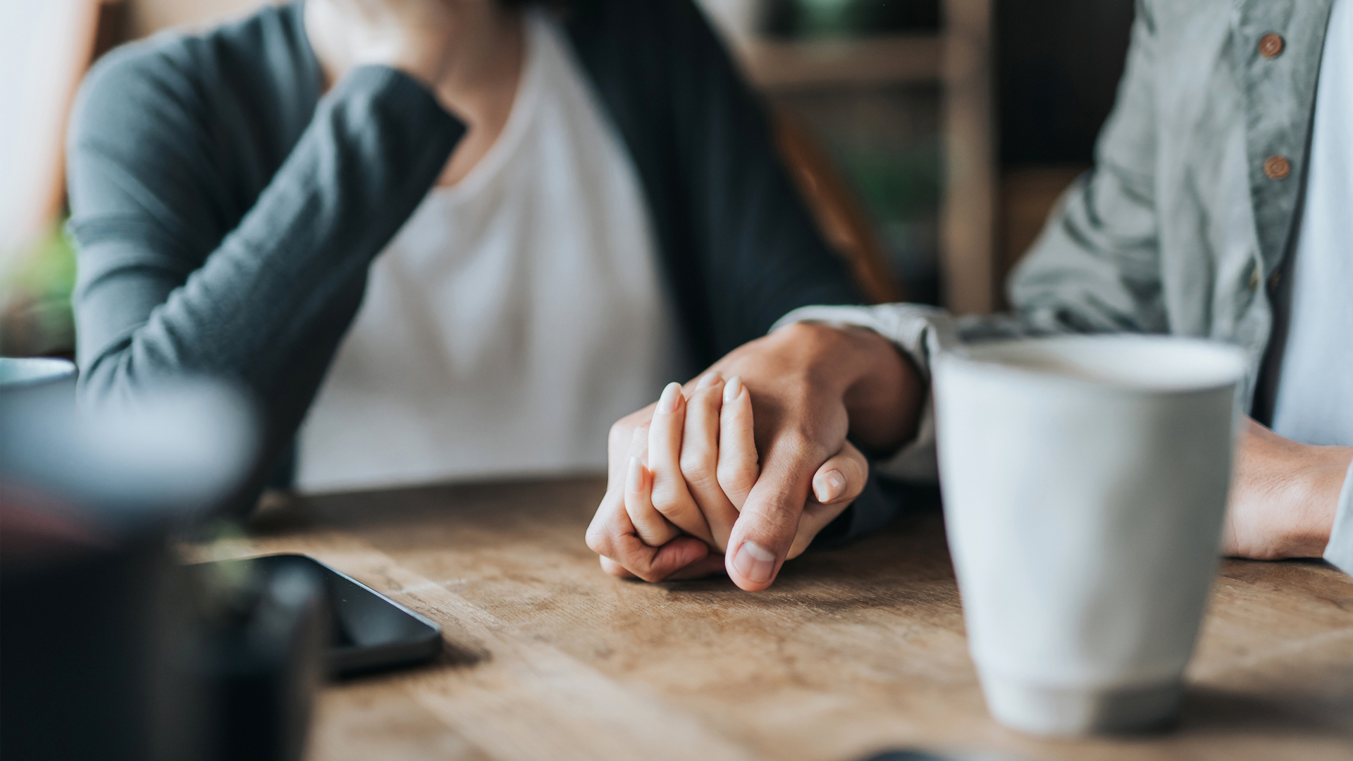 couple holding hands to comfort one another