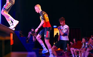 Tim Merlier leads Fabio Jakobsen onto the stage at Soudal-QuickStep's team presentation