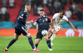 Harry Kane, right, is crowded out by Scotland’s John McGinn, centre, and Scott McTominay