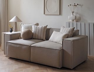 a beige sofa dressed with throw pillows