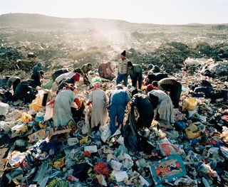 People pictured circled around a rubbish dump