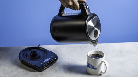 an all-black ninja electric kettle with a precision temperature base for specialty tea and general kitchen use photographed making coffee