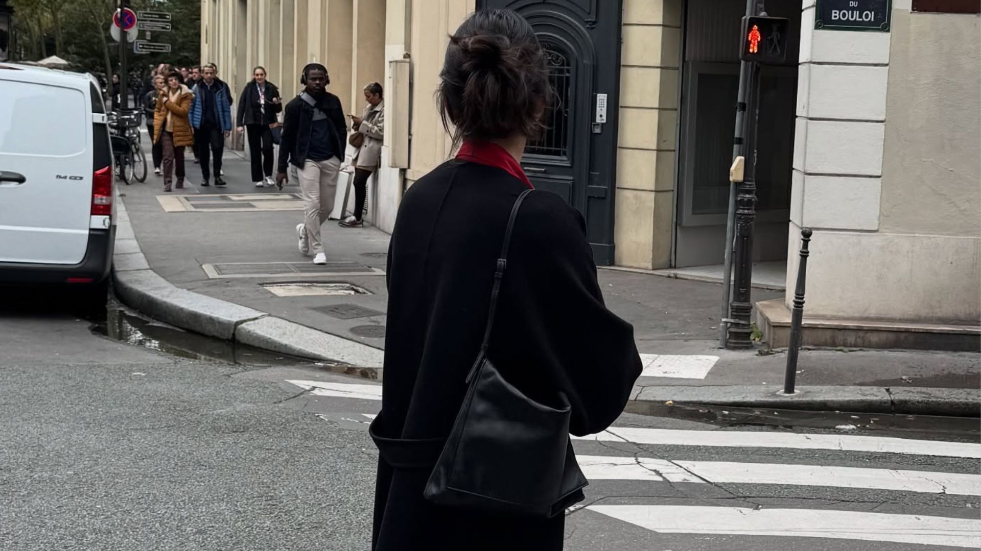 Kendall Jenner stands on a road in New York wearing a black wool coat, black trousers and rounded-toe shoes