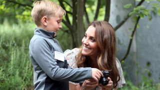 Kate Middleton teaching a young boy how to use a camera