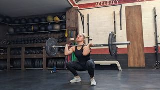 Emma Ray demonstrates the squat part of the barbell thruster