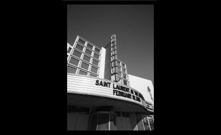 A black and white photo of a building with a sign on it that says "Saint Laurent at The Palladium".