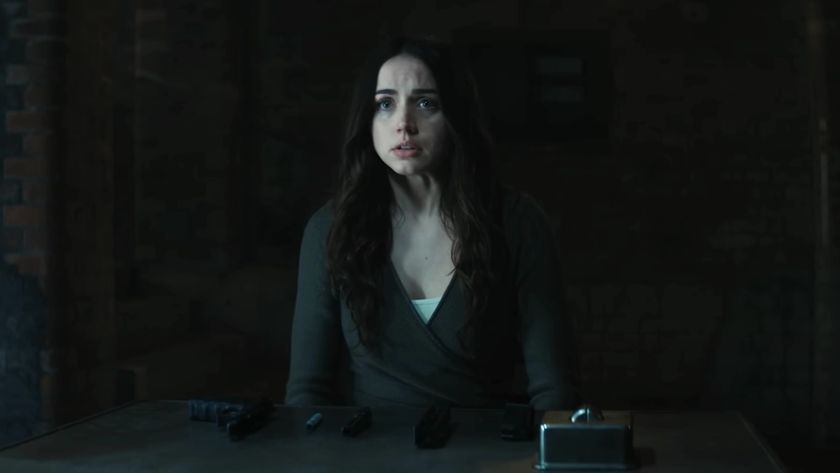 Ana de Armas&#039; Eve sitting at table with a disassembled gun on it in Ballerina