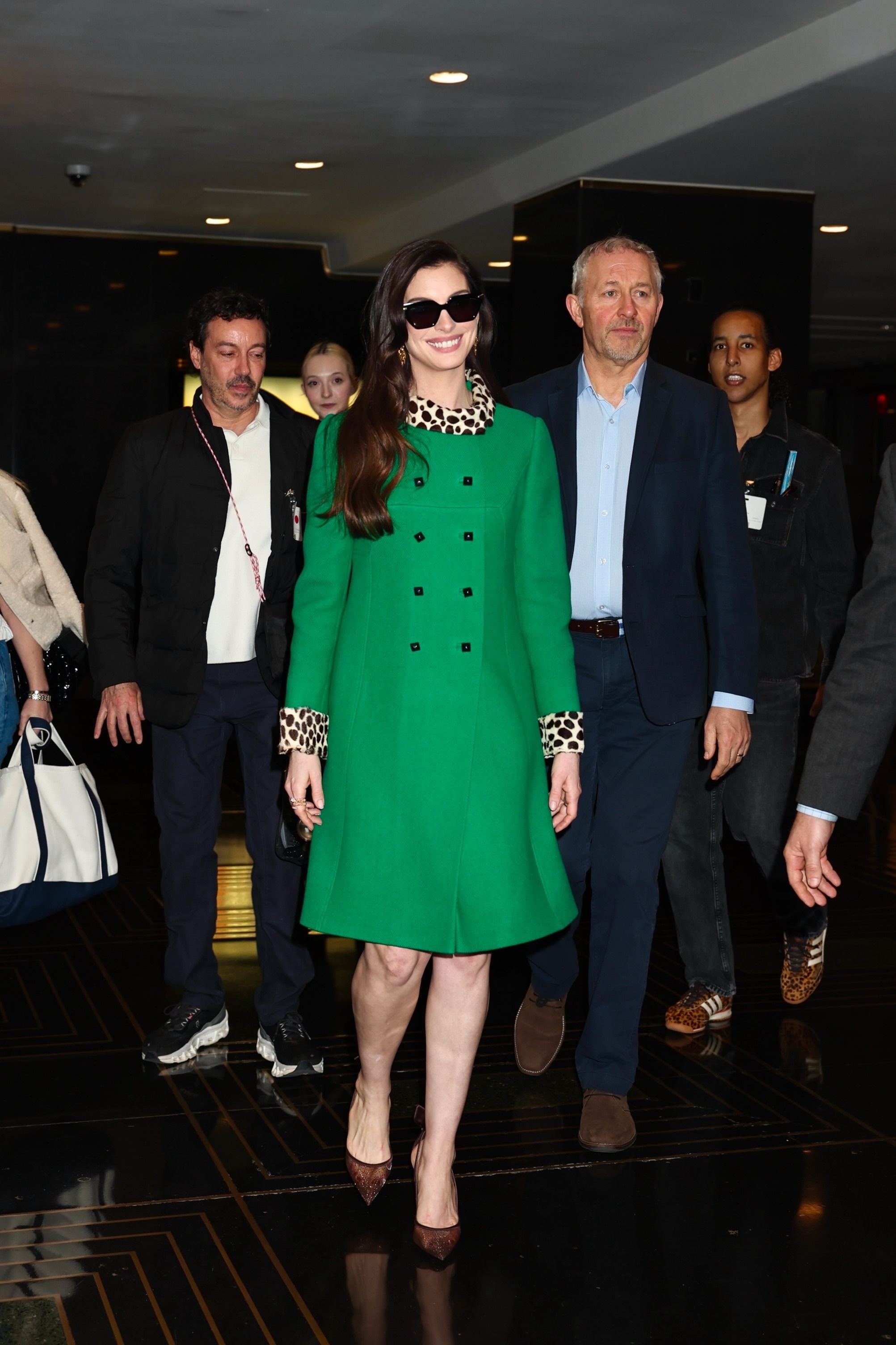 Anne Hathaway wore the green coat with leopard-print trim from the Devil Wears Prada on the Devil Wears Prada 2 press tour