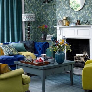 living room with blue sofa and floral wallpaper