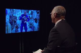 NASA Administrator Charles Bolden (right) speaks to one-year astronaut Scott Kelly on the International Space Station via a video link on March 30, 2015.