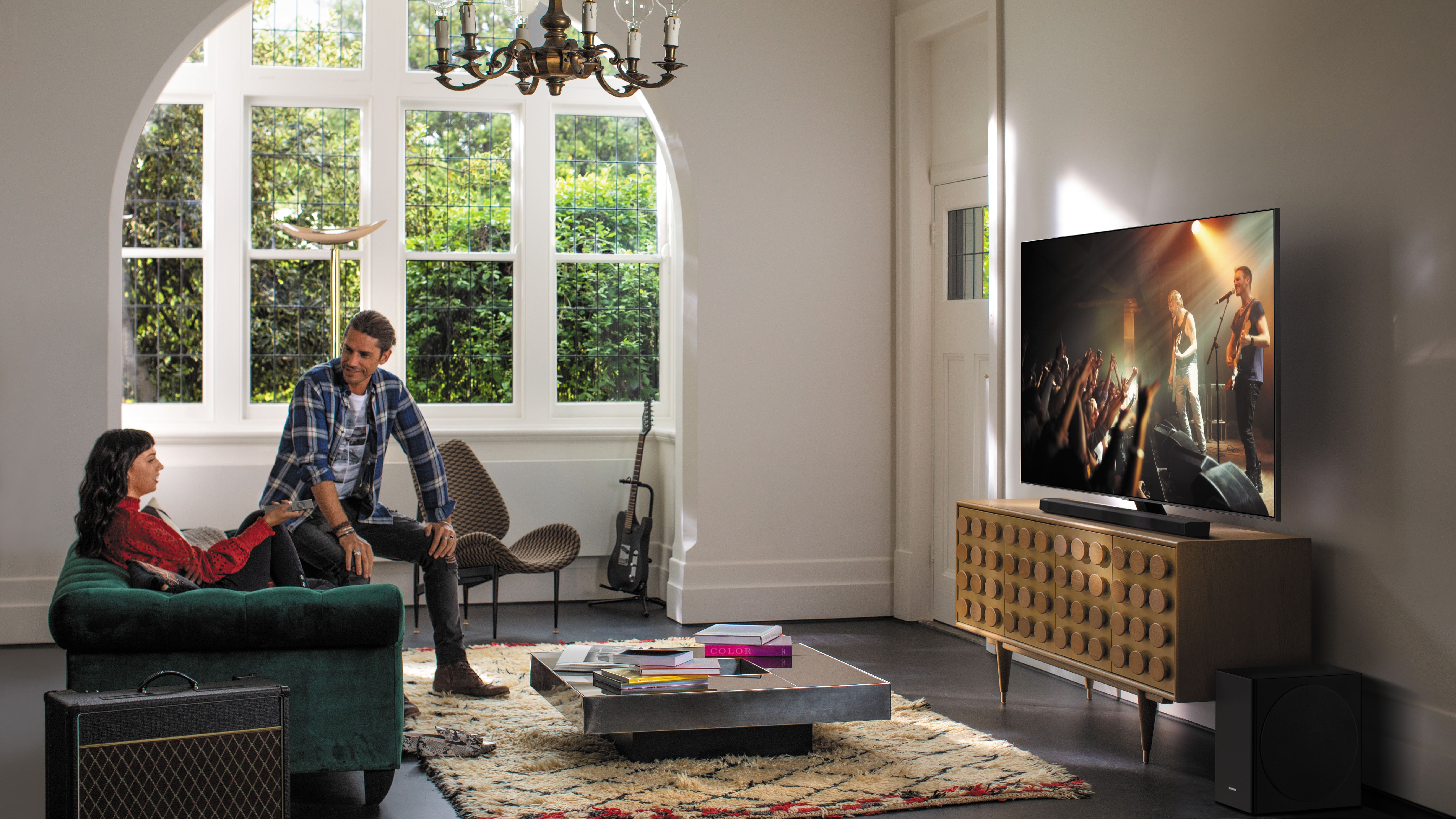 A man and a woman watching a Samsung QLED TV in a living room