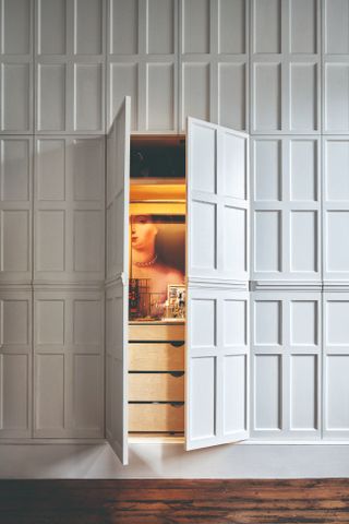 A wood panel wall with a concealed door