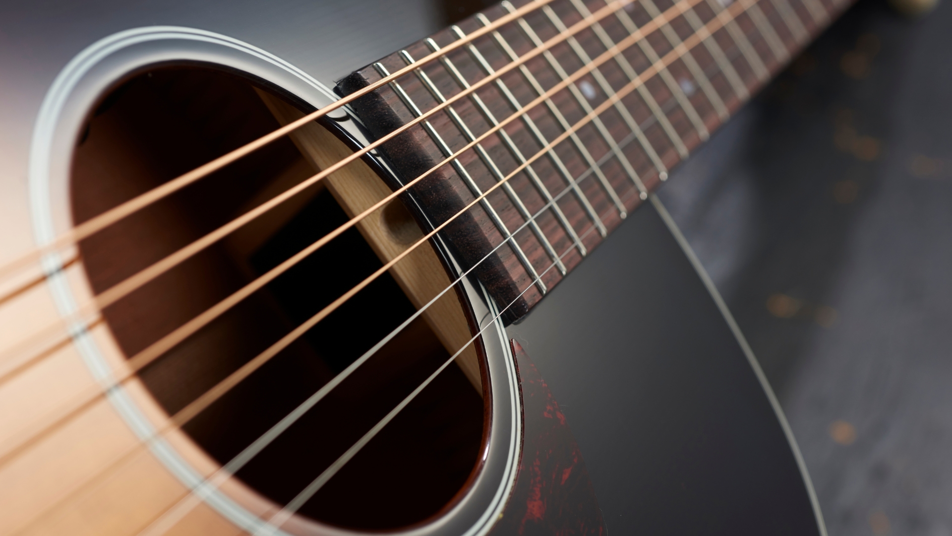 Close up of acoustic guitar strings on a sunburst acoustic guitar