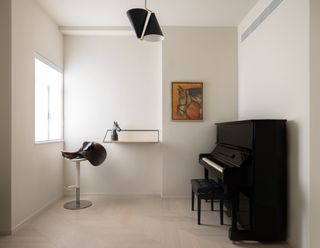 minimalist study with piano and artwork