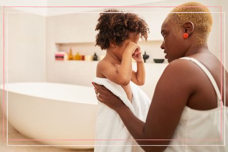 A mother comforts her son after a bath and patting him dry with a towel, one of the ways to soothe dermatitis in children