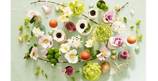Ester table decorations using flowers, twigs with buds and egg cups to create a natural tablescape