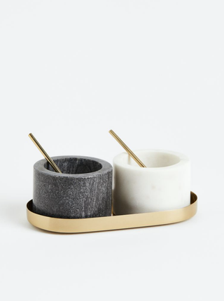 2 black and white pots side together in a gold tray with gold spoons peeking out