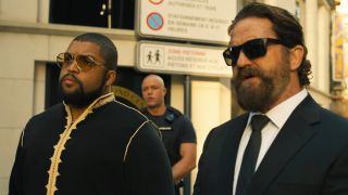 oshea jackson jr and gerard butler wear sunglasses and walk side by side down a european street in den of thieves 2