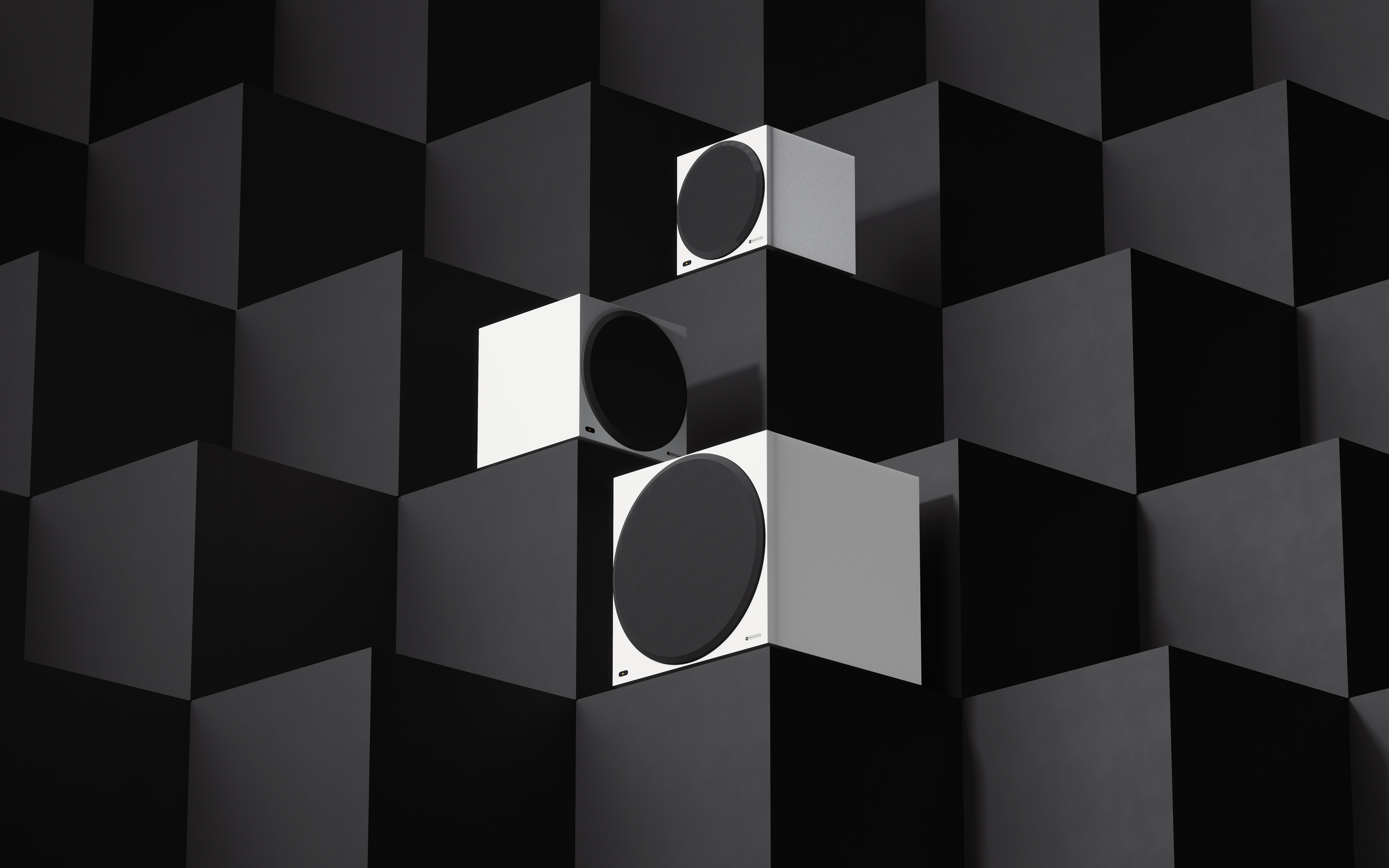 three white subwoofers on a black background