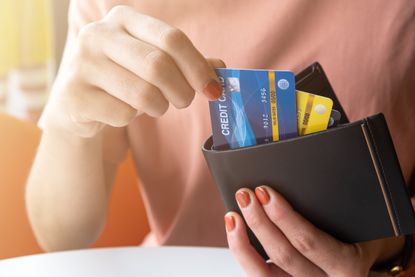 Woman taking a credit card out of a wallet.