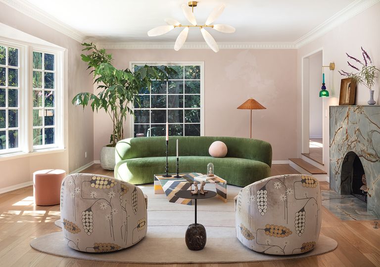 elegant modern living room with green curved sofa, plaster pink walls and stripy coffee table