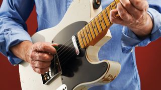 Man playing Fender Telecaster guitar in studio setting