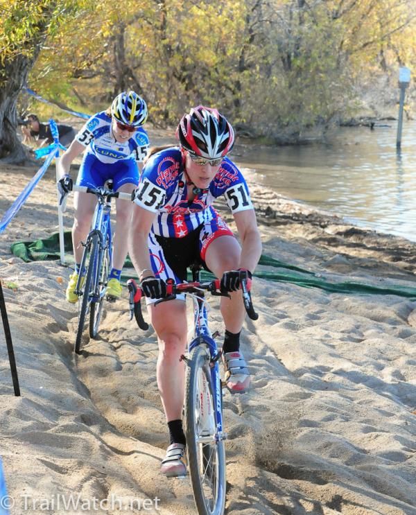 Katie Compton (Planet Bike) riding the deep sand along the beach while Gould rides in her tracks