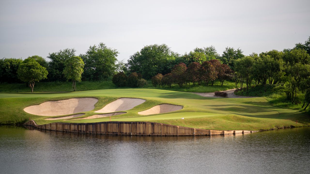 A golf green seen on the edge of water