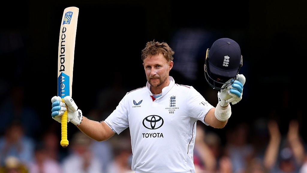 Joe Root raises his bat and helmet to celebrate scoring a century in the Ashes 5th Test against Australia at Sydney.