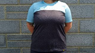 A loose-fitting trail t-shirt with a turquoise upper panel over the chest and arms, and a grey and black leopard print panel from the bust downwards